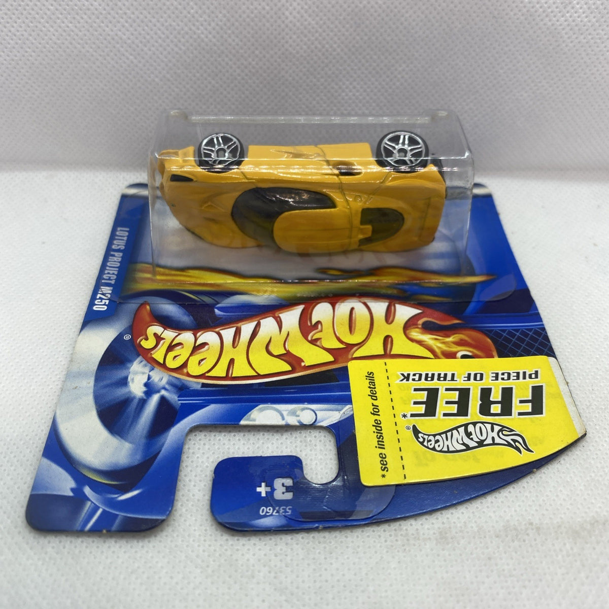 Yellow die-cast sports car in clear blister pack viewed from above