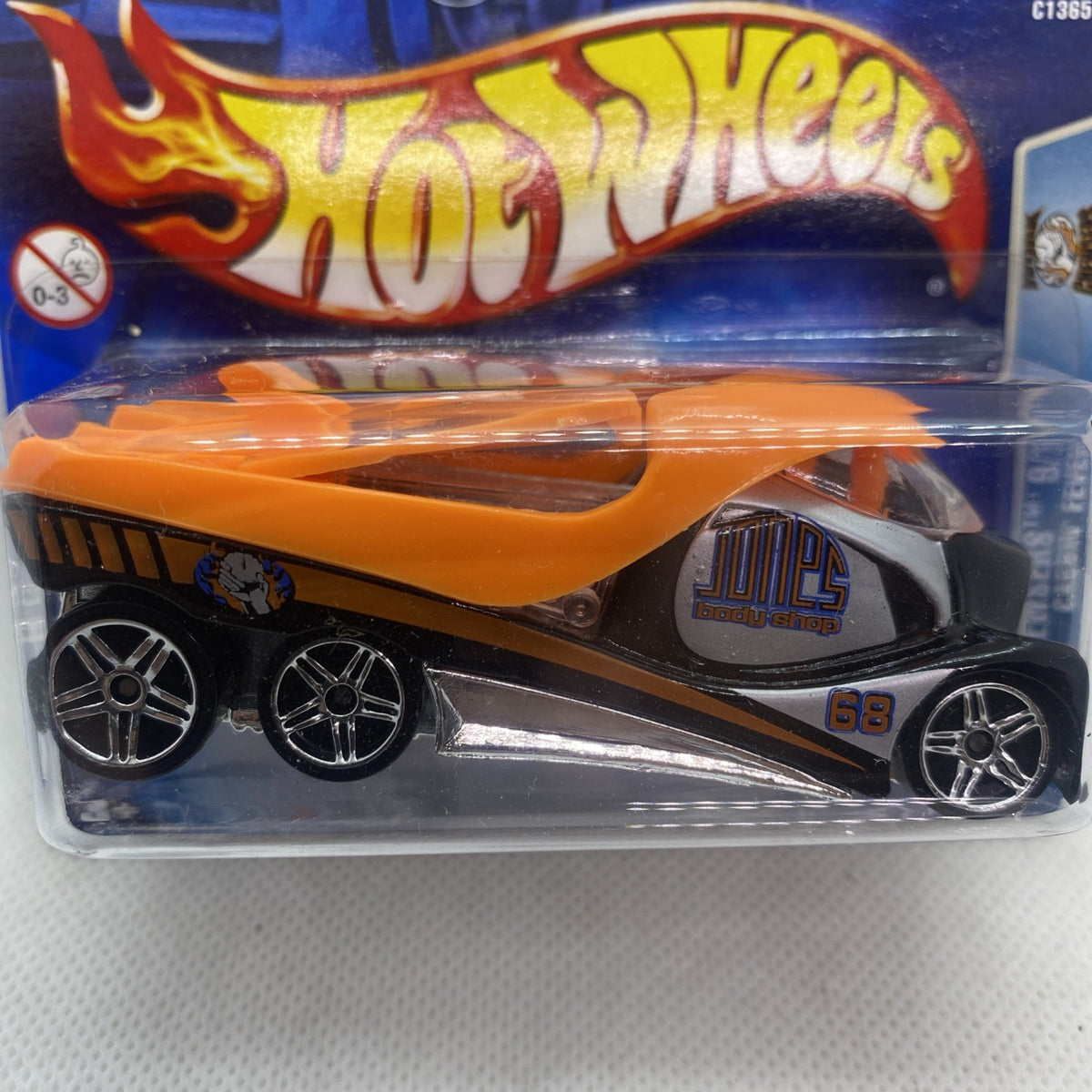 Hot Wheels die-cast toy car in clear blister, orange and black flame livery, front close-up.