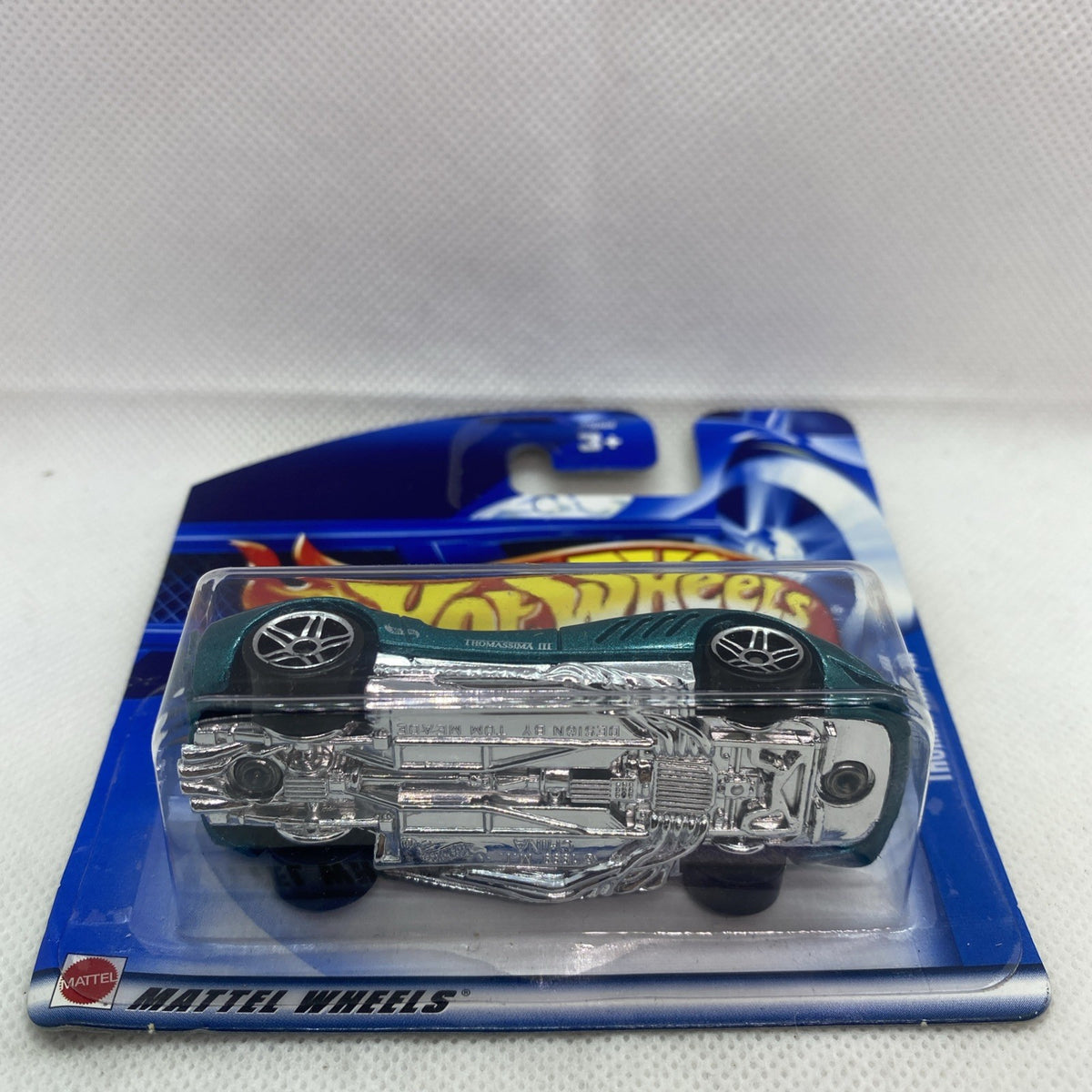 Hot Wheels car blister showing chrome underside, dark green top, sealed