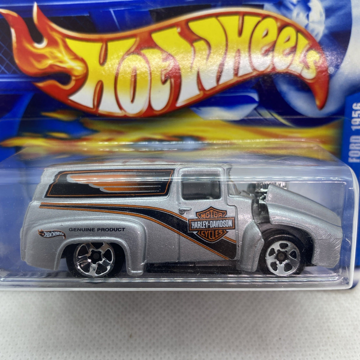 Close-up of Hot Wheels blister pack showing silver pickup truck with orange stripes