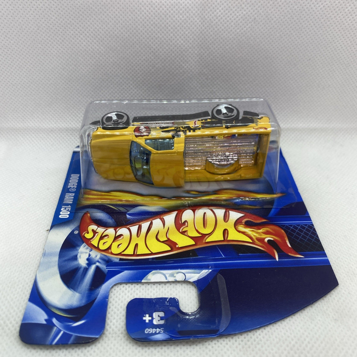 Hot Wheels Dodge Ram 1500 toy on blister card, yellow truck with clear cover.