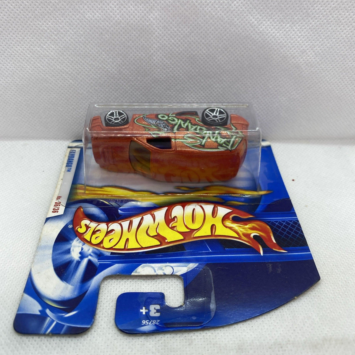 Hot Wheels die-cast car in blister, orange body with green flame decals and chrome wheels