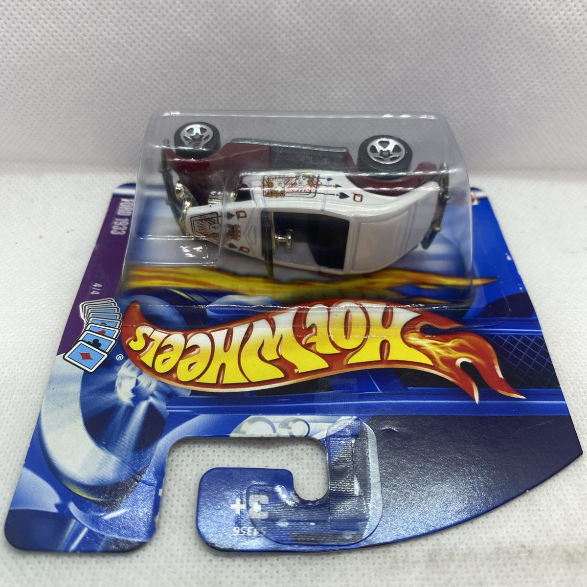 Hot Wheels die-cast car in sealed blister, top view showing wheels and chassis