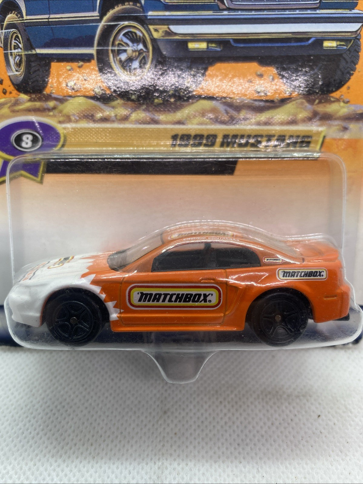 Close-up of sealed Matchbox orange and white 1999 Mustang die-cast car