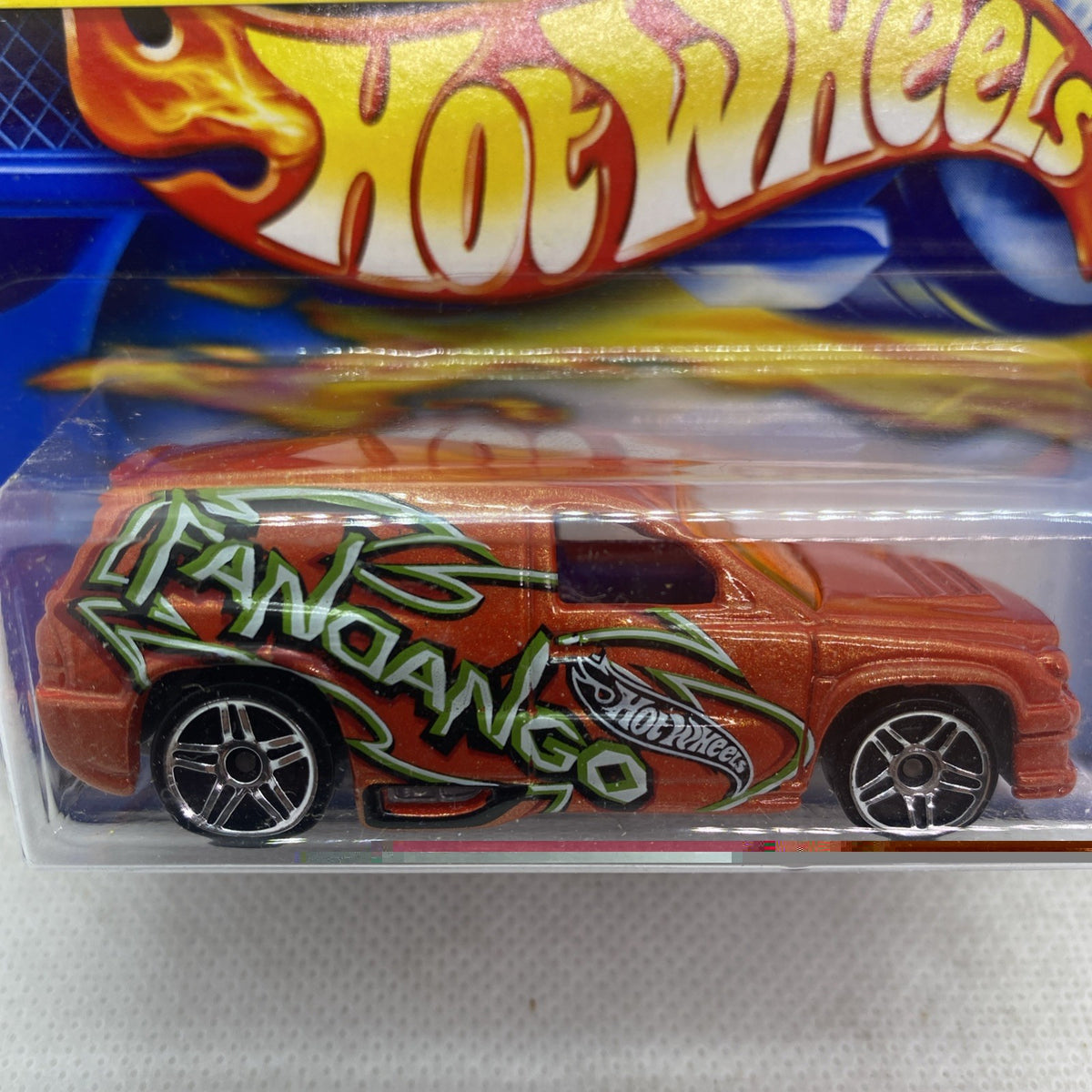 Hot Wheels orange die-cast car close-up, green graffiti-style design and chrome wheels