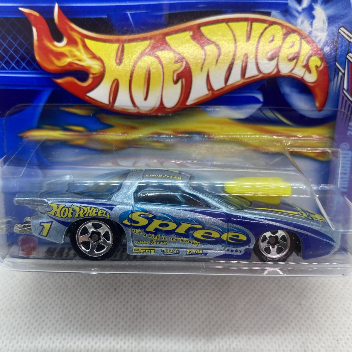 Hot Wheels die-cast car blister close-up, blue car with yellow stripe and flame logo