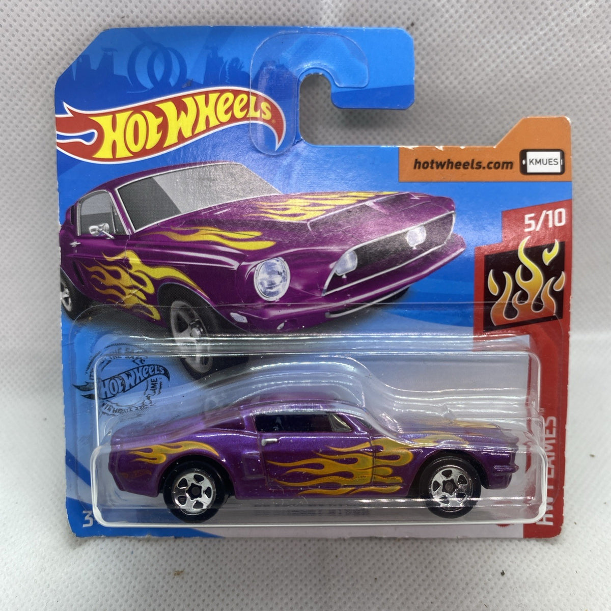 Hot Wheels die-cast car in blister pack, purple body with yellow flame graphics and black wheels