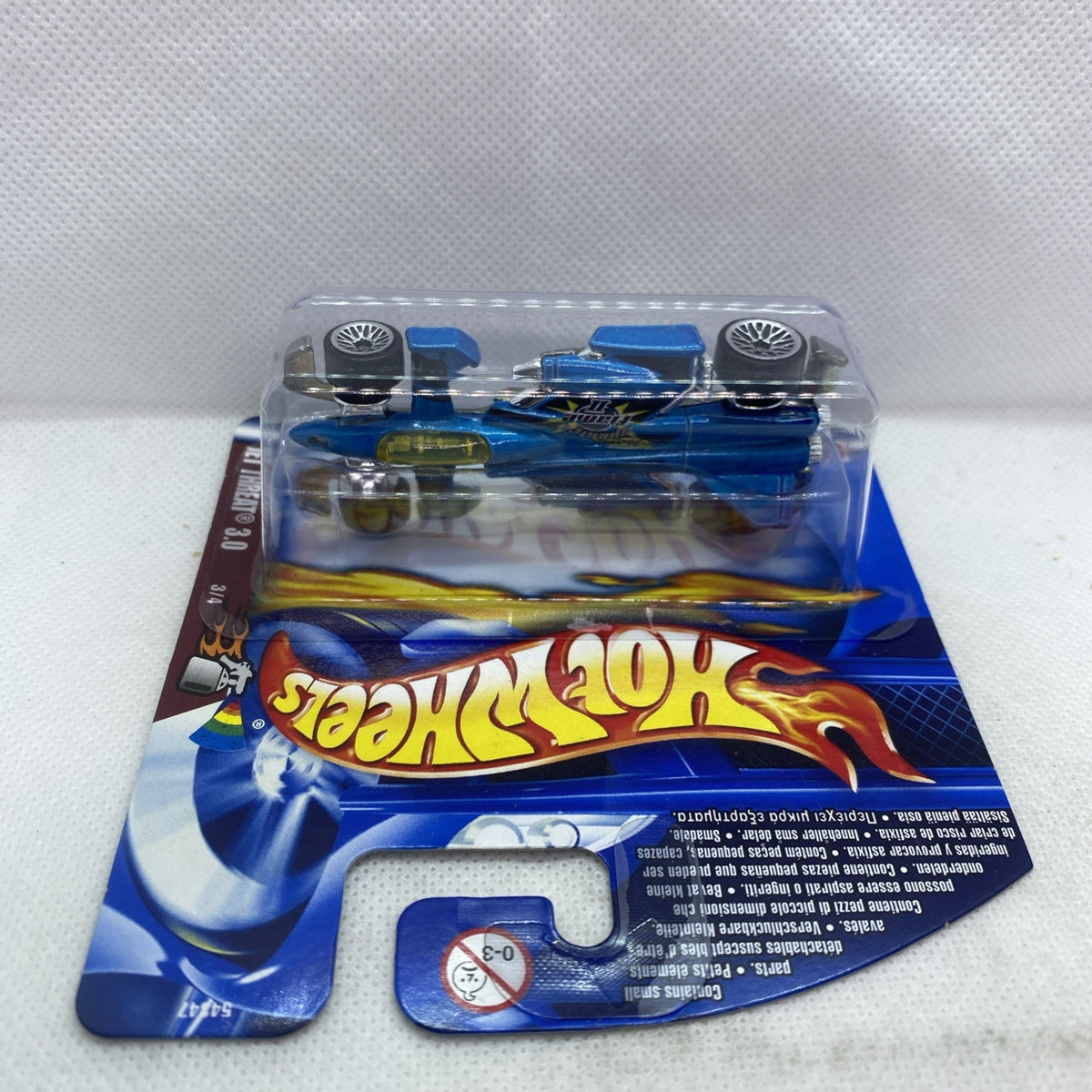 Blue die-cast race car in blister pack, side view through clear plastic