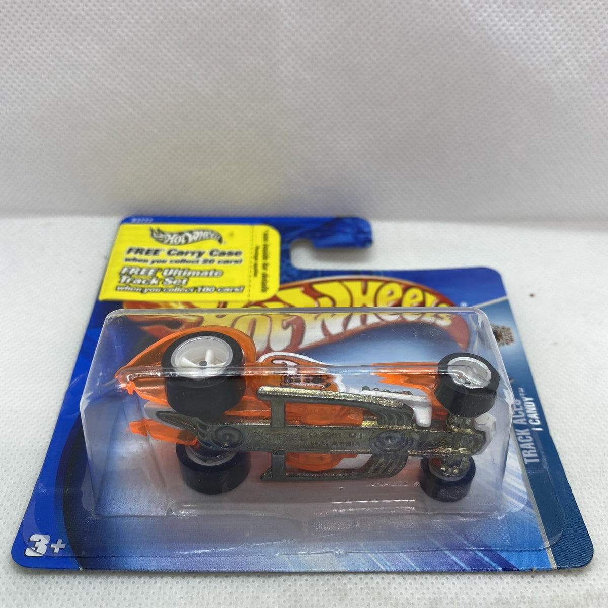 Hot Wheels orange and white race car toy in blister package, side view