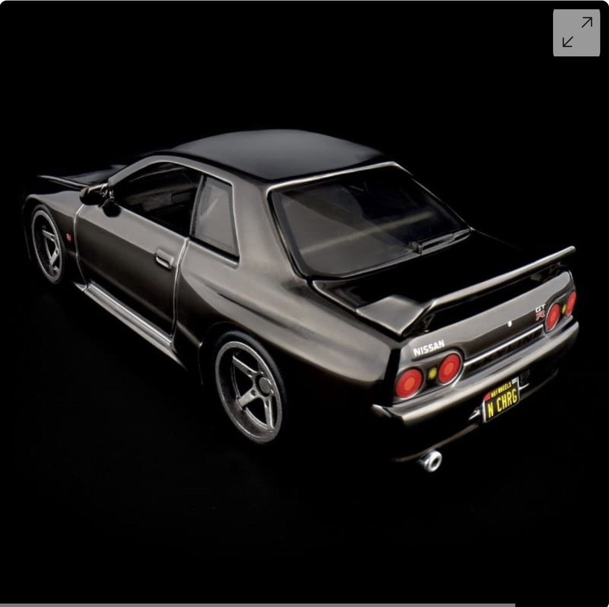 Die-cast sports car model, side-rear three-quarter view with rear spoiler and red tail lights