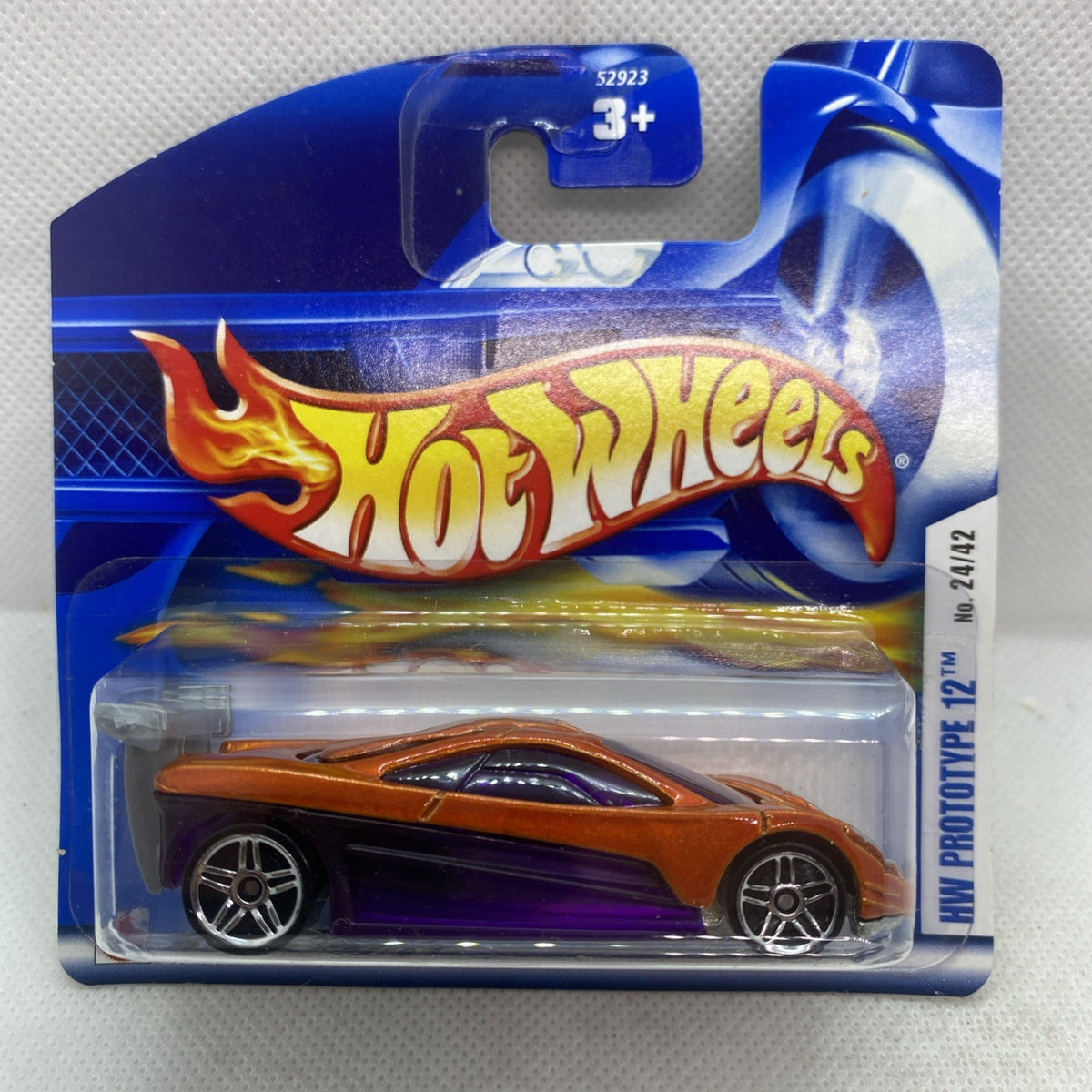 Hot Wheels die-cast car: orange body, purple base, sealed blister pack (Prototype 12)