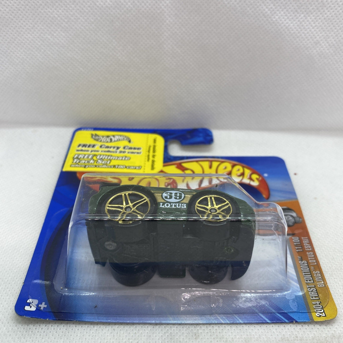 Green Hot Wheels toy car in blister on short card, back label side view