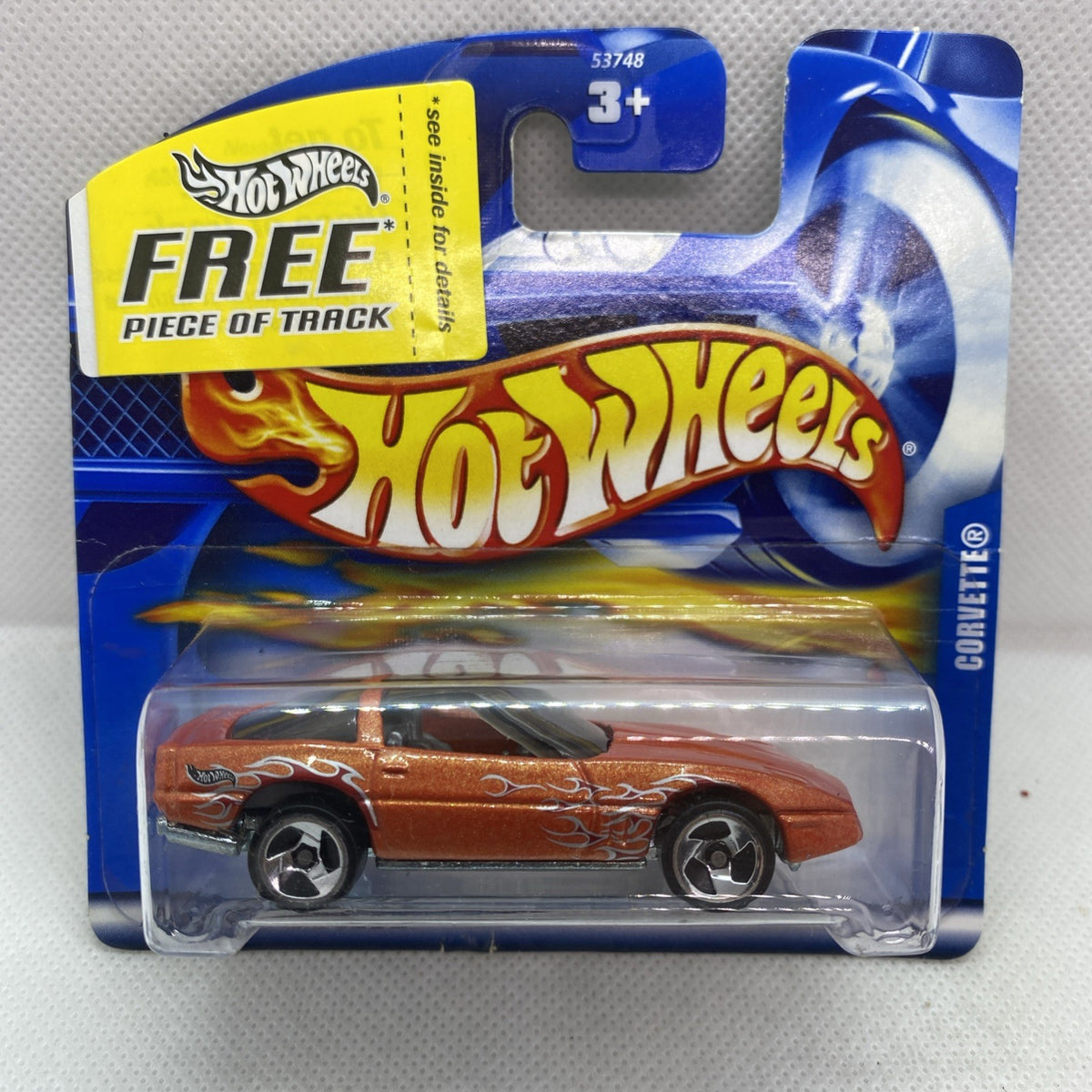 Orange die-cast Corvette toy car in blister pack with Hot Wheels Free track label