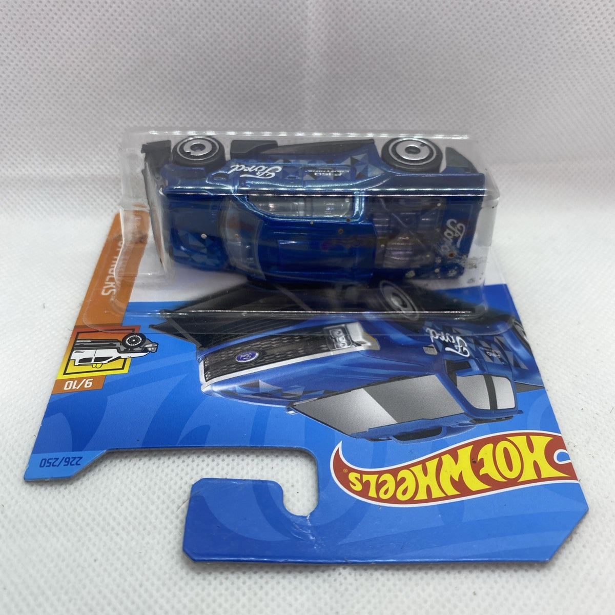 Hot Wheels die-cast pickup truck in blue and clear blister, side view