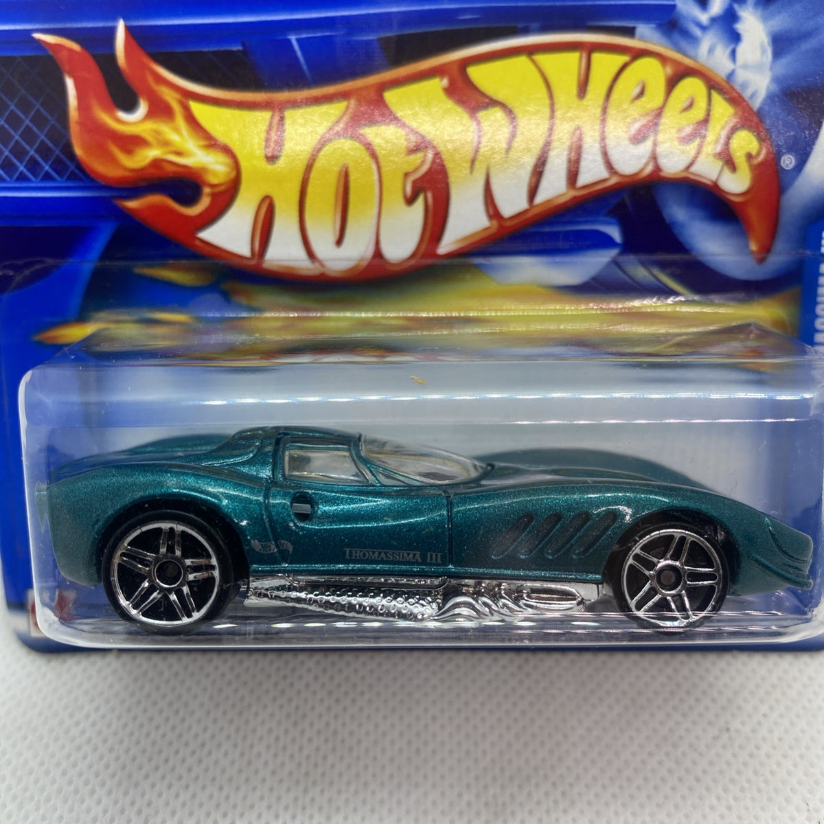 Hot Wheels die-cast car blister close-up: green sports car, flame Hot Wheels logo