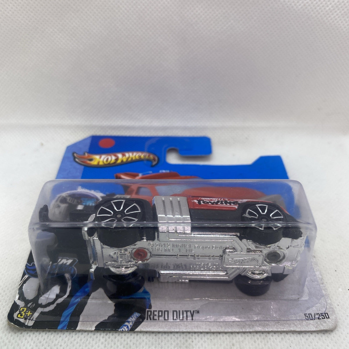 Hot Wheels die-cast tow truck with silver front details, carded 1:64.