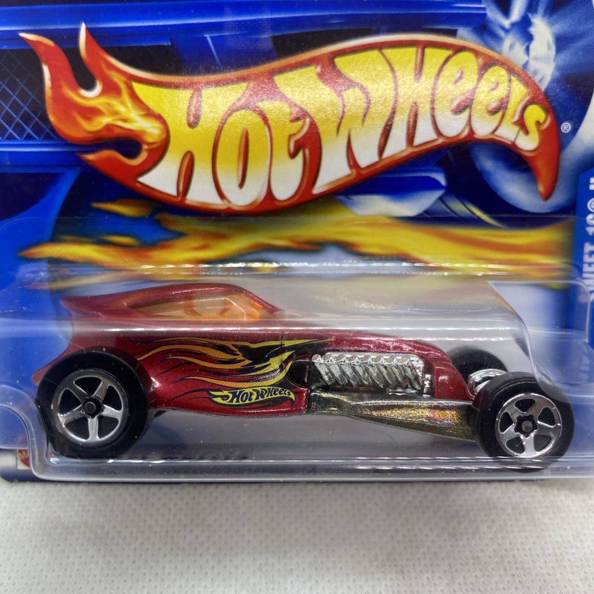 Hot Wheels die-cast car blister pack, close-up of red maroon flame graphics and wheels
