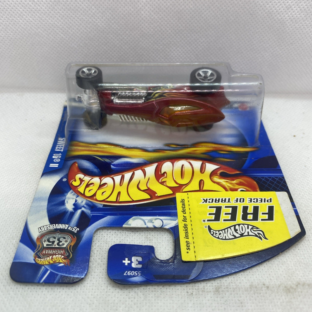Hot Wheels die-cast car in blister pack, maroon body, silver engine and exhaust