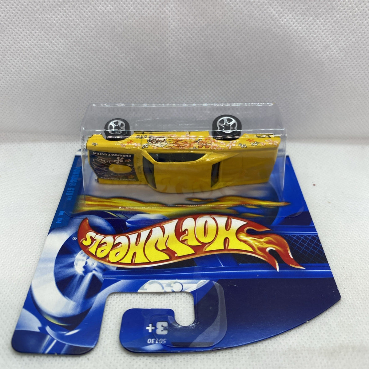 Yellow die-cast car front view on clear blister card, Hot Wheels branding