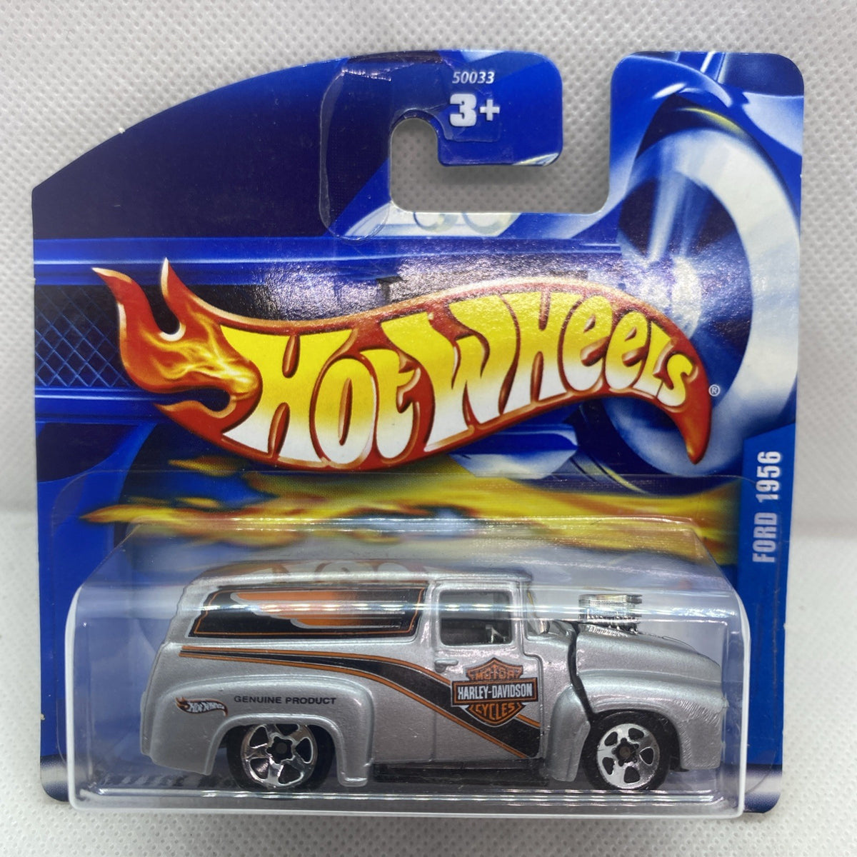 Hot Wheels car blister pack on blue card, 3+ symbol, silver truck with orange accents