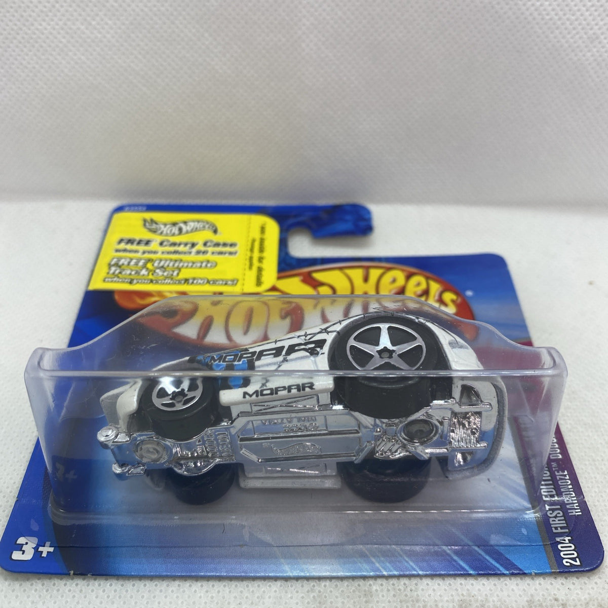 Hot Wheels die-cast car in blister pack, white car with black wheels and MOPAR branding