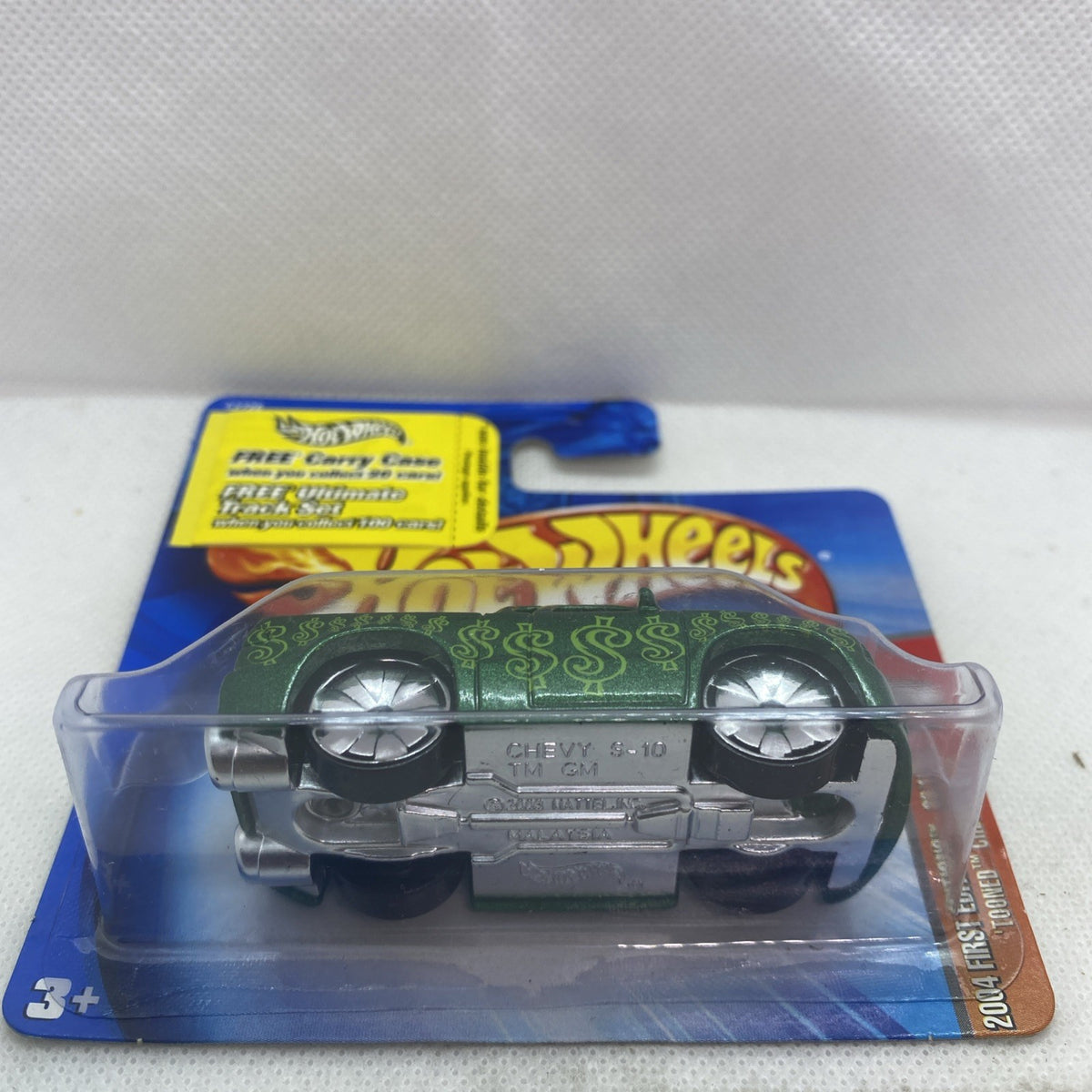 Hot Wheels green die-cast truck in clear blister, front close-up on blue card