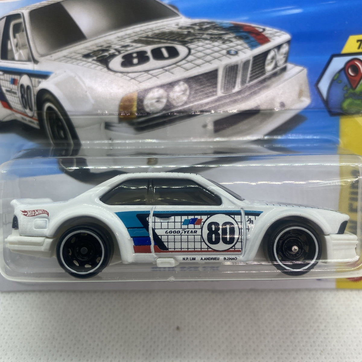 Close-up of white die-cast car with blue stripe and number 80 in clear blister