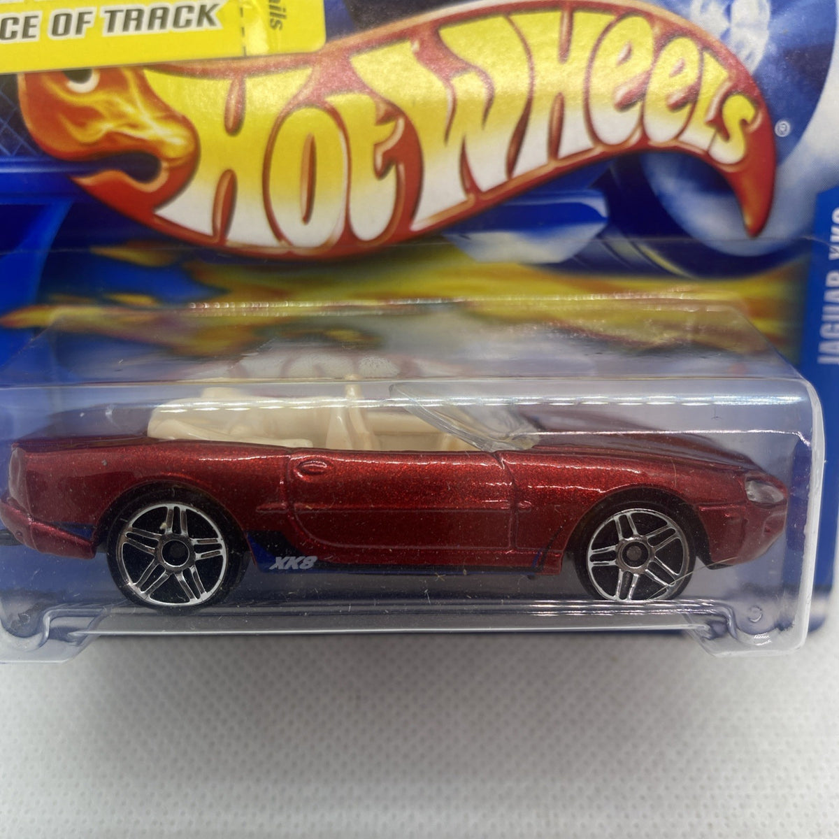Close-up of red Jaguar XK8 die-cast toy car with Hot Wheels packaging