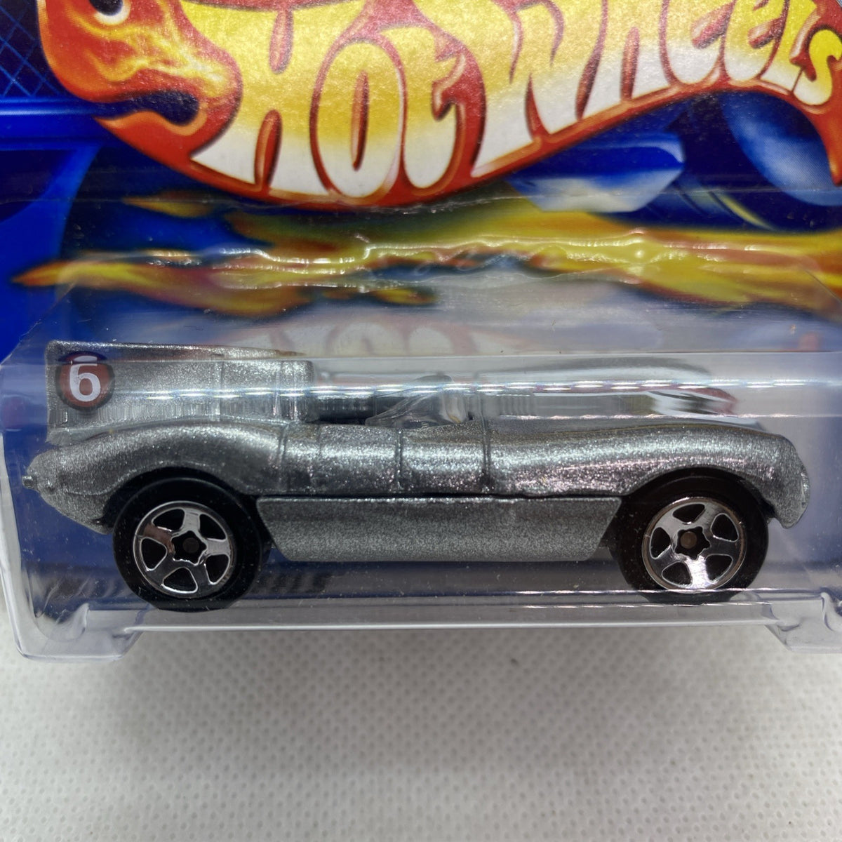 Hot Wheels Jaguar D-Type die-cast car close-up in blister, silver body and wheels