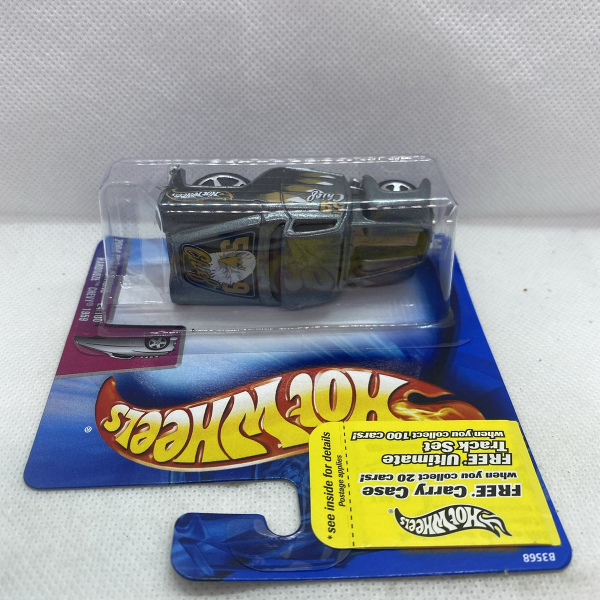 Toy die-cast car in clear blister on card, dark gray with gold stripe and black wheels