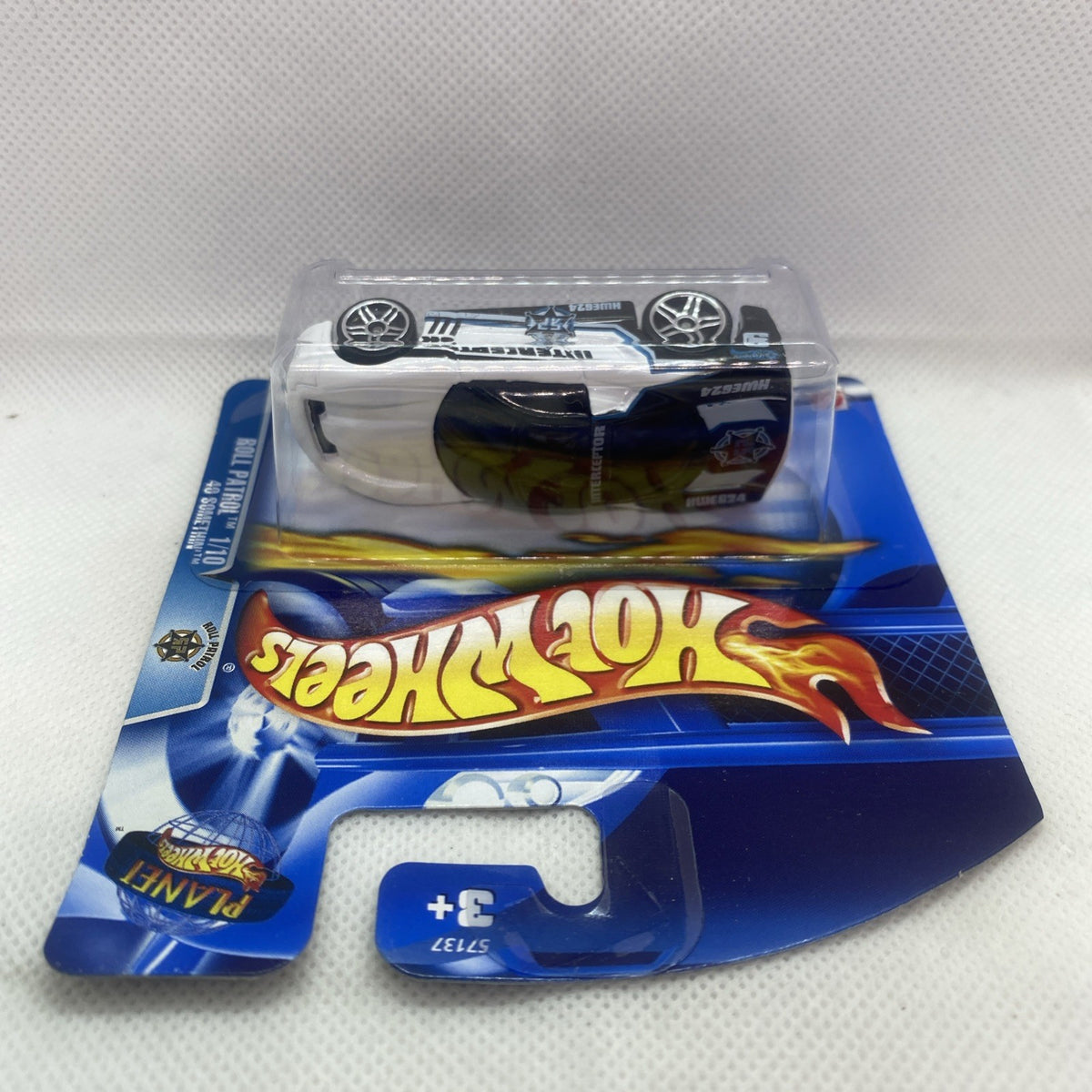 Hot Wheels die-cast car on card, white top with black stripe and visible wheels
