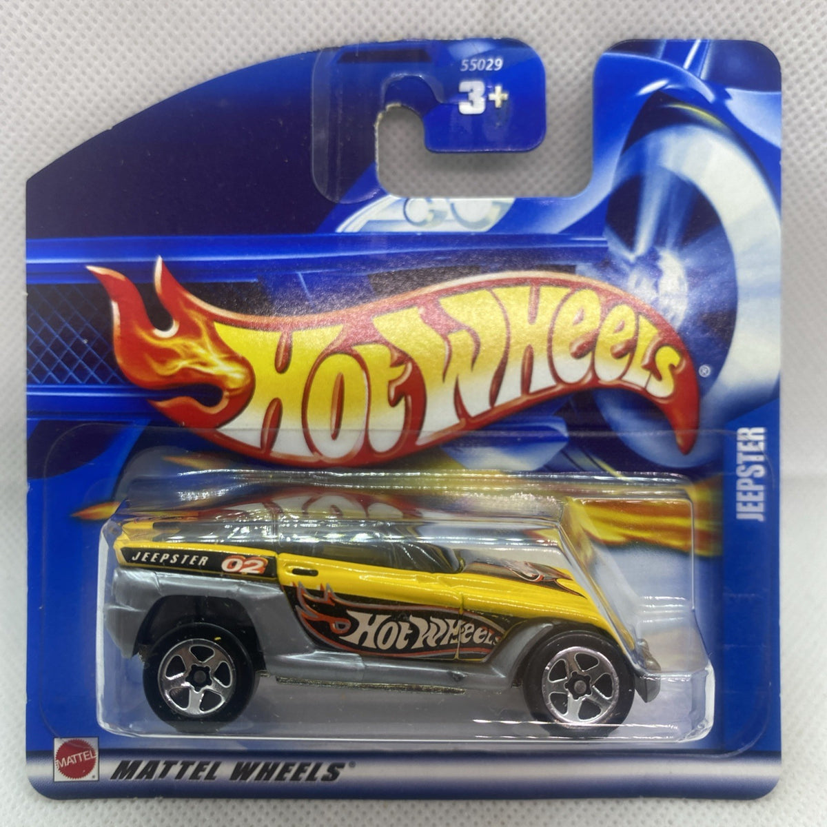 Hot Wheels Jeepster 2002 die-cast car in blister with yellow and black graphics on blue card