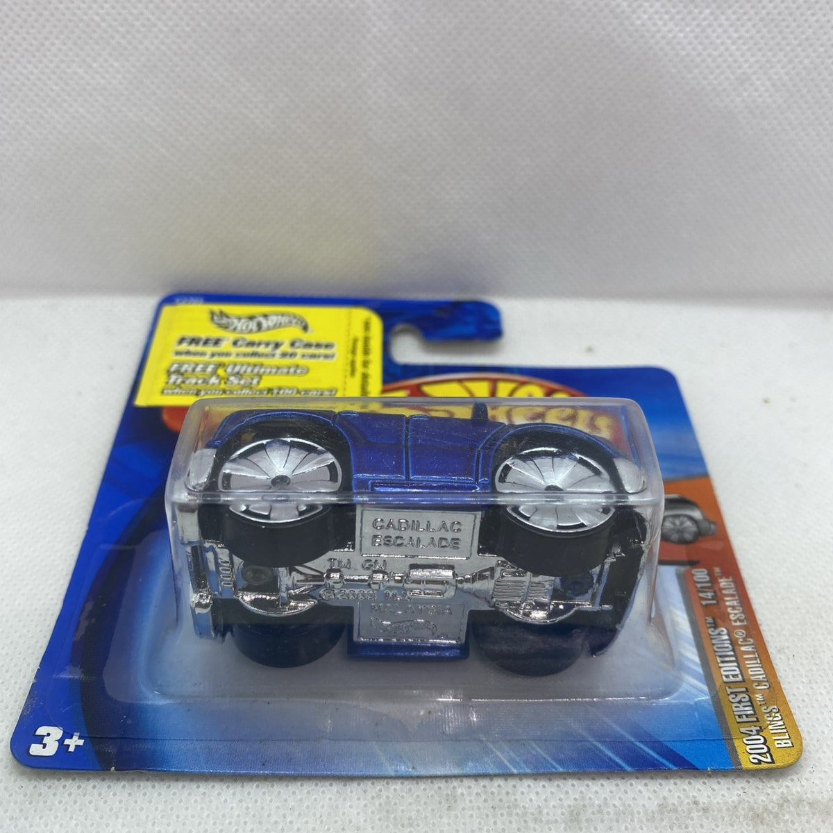 Blue die-cast SUV toy shown in clear blister on Hot Wheels card, age 3+
