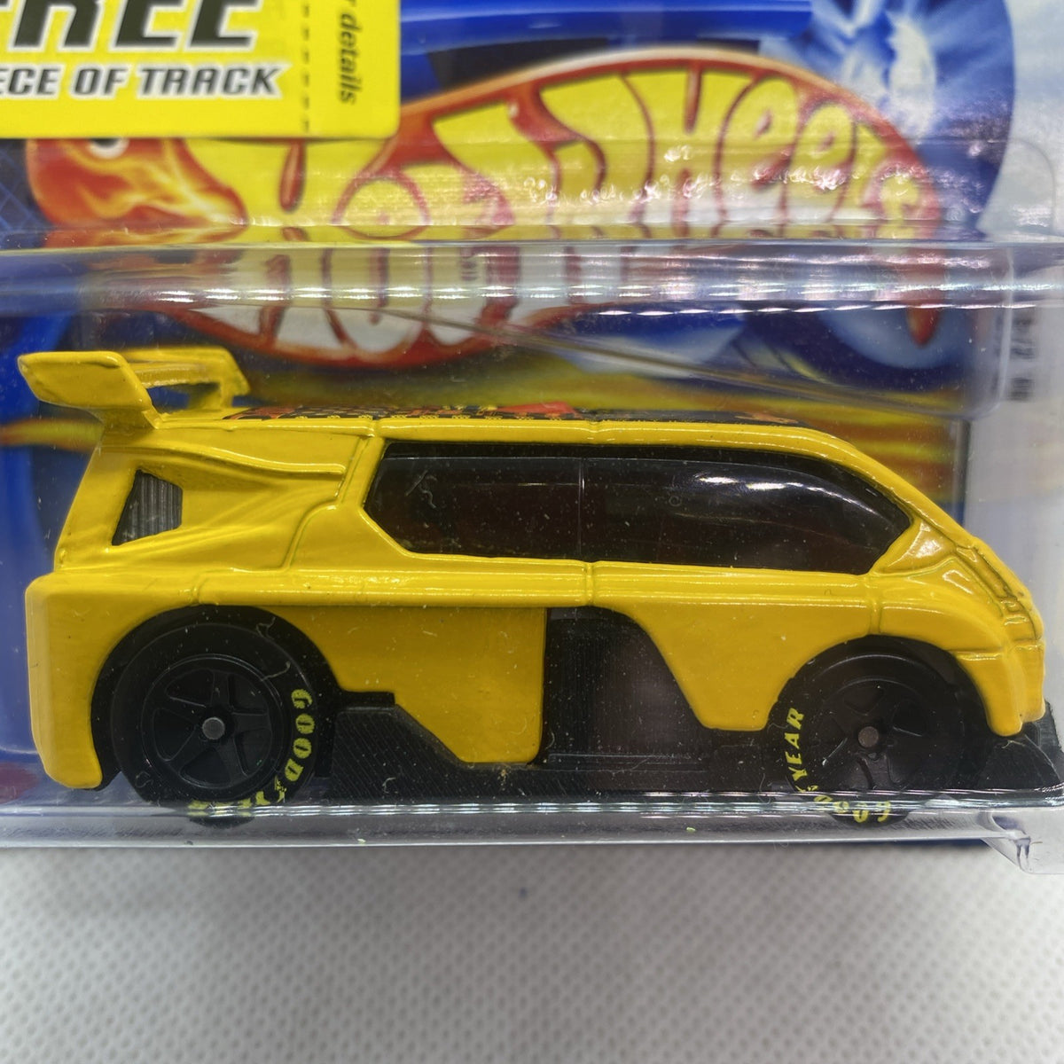 Hot Wheels yellow car close-up in clear blister pack, black wheels and windows