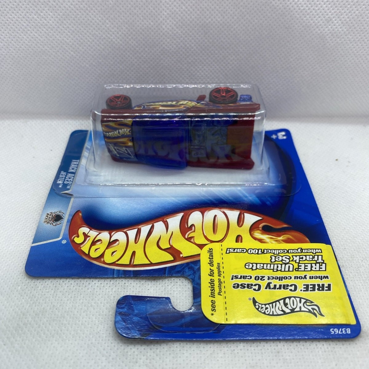 Hot Wheels die-cast race car in blister, maroon and blue flame decals, red wheels.
