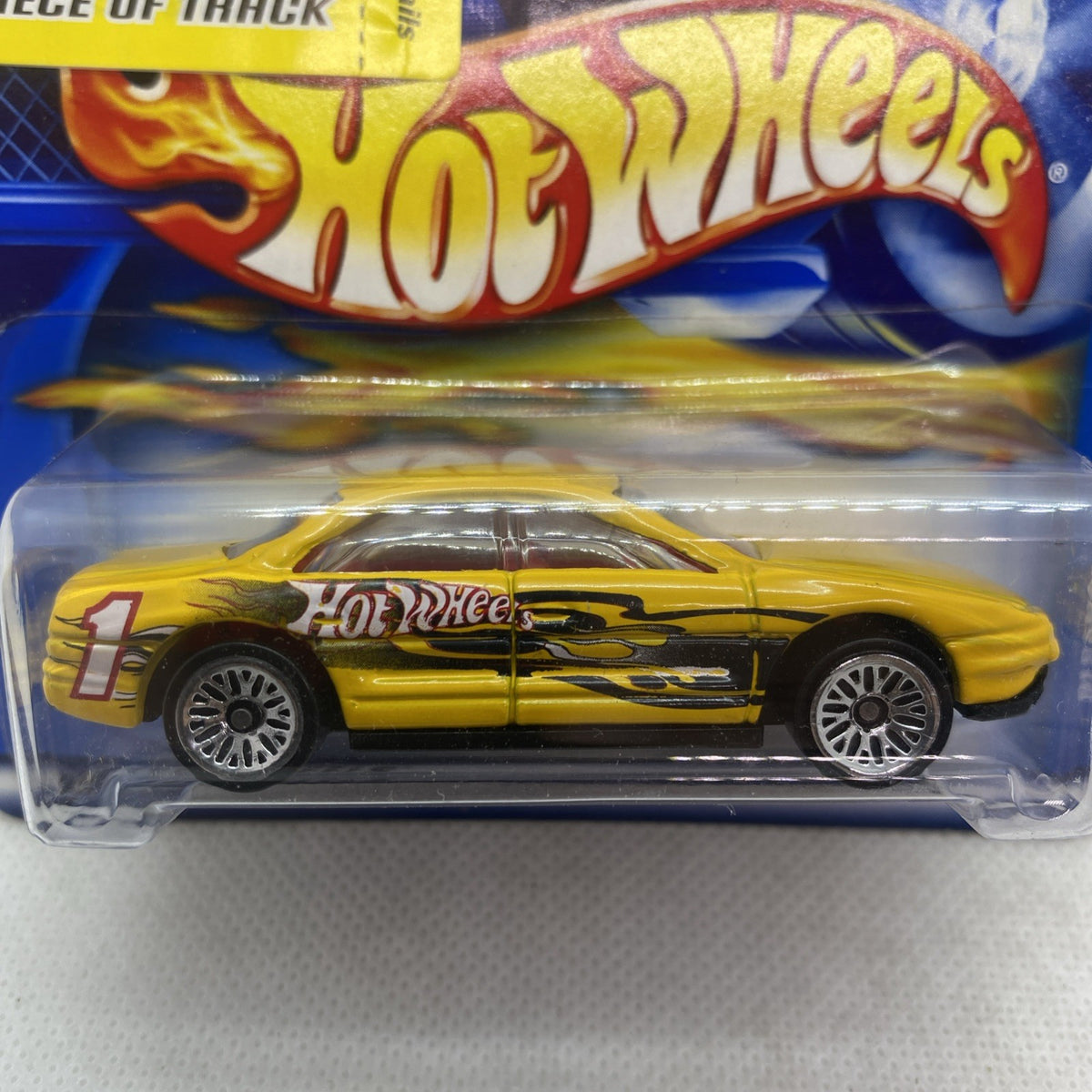 Hot Wheels Oldsmobile Aurora 2001 yellow die-cast car close-up in clear blister