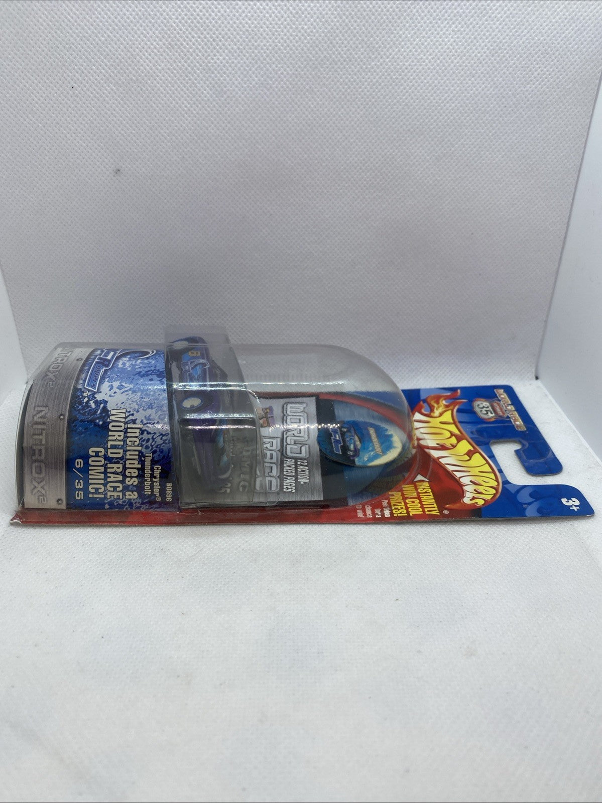 Hot Wheels World Race die-cast car in blister pack, side view from left