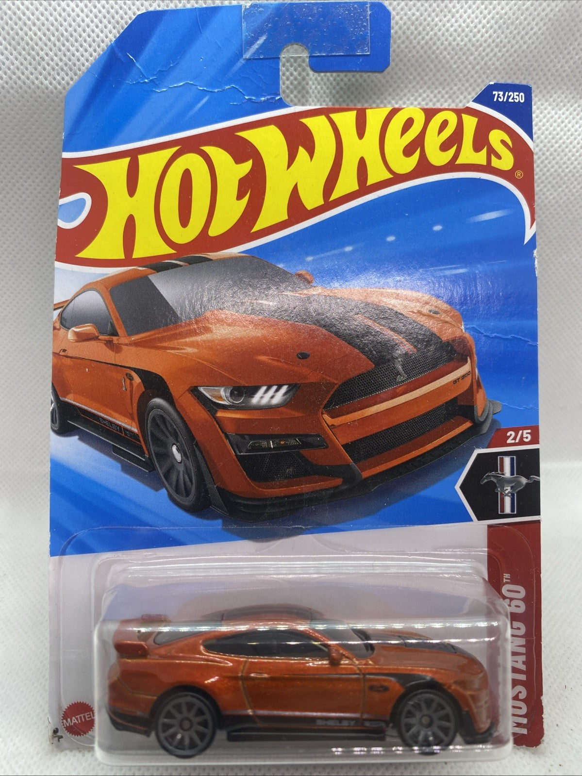 Hot Wheels die-cast car in blister pack, orange Mustang Shelby GT500.