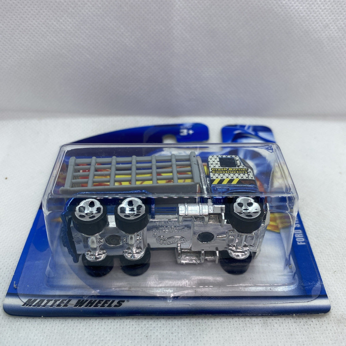 Hot Wheels blue Ford stake bed truck in blister, front view with wheels and grille detail