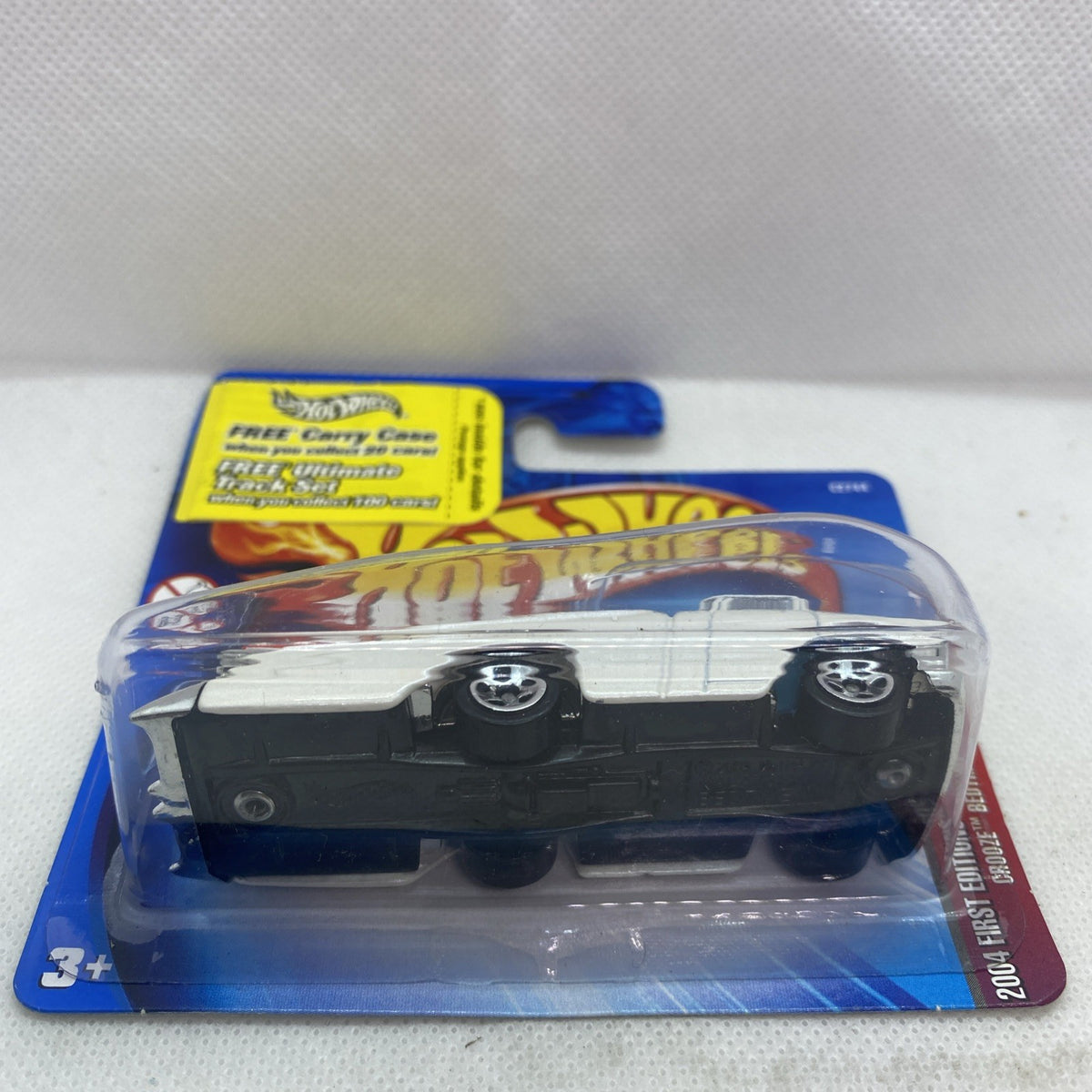 Hot Wheels die-cast car in blister pack, front view with white body and black base