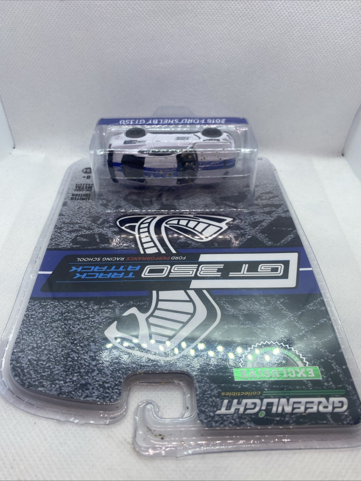 Sealed die-cast race car in blister, top view of white Ford Shelby with black wheels