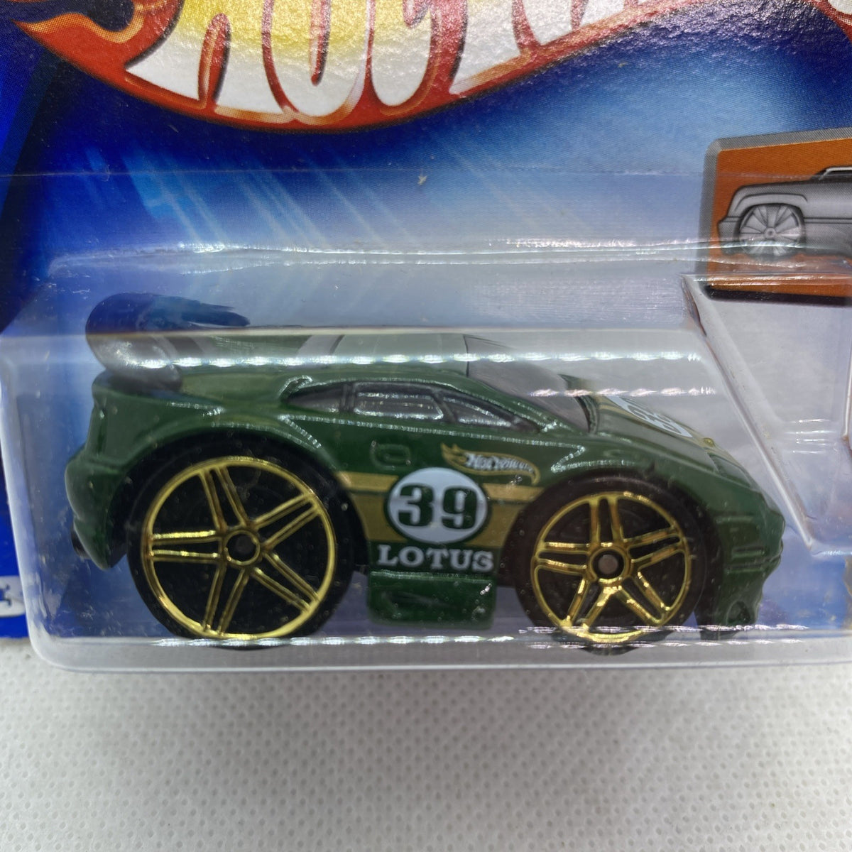 Green die-cast toy car with gold wheels, number 39 Lotus, in clear blister