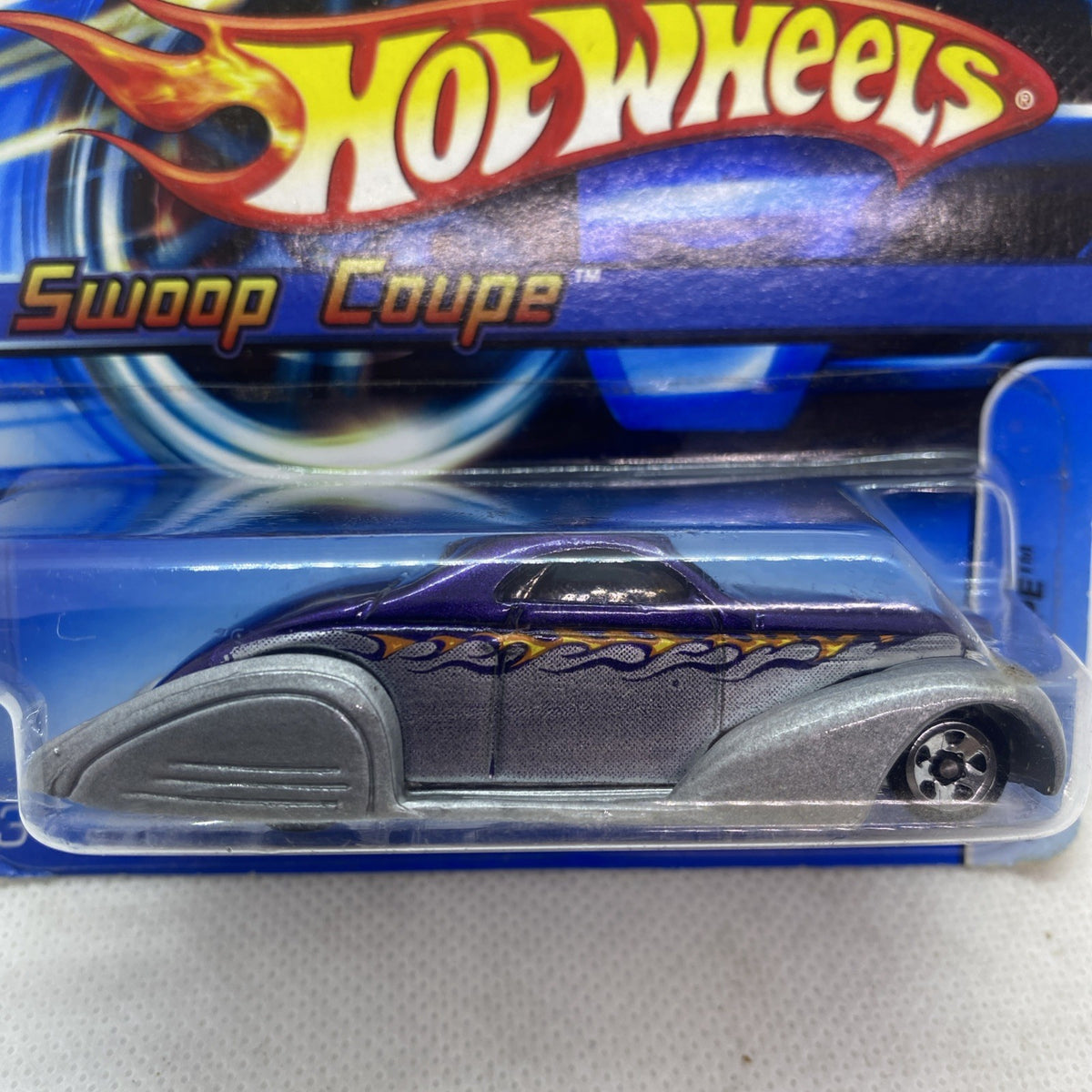 Gray Hot Wheels Swoop Coupe toy car with flame graphics in sealed blister close-up.