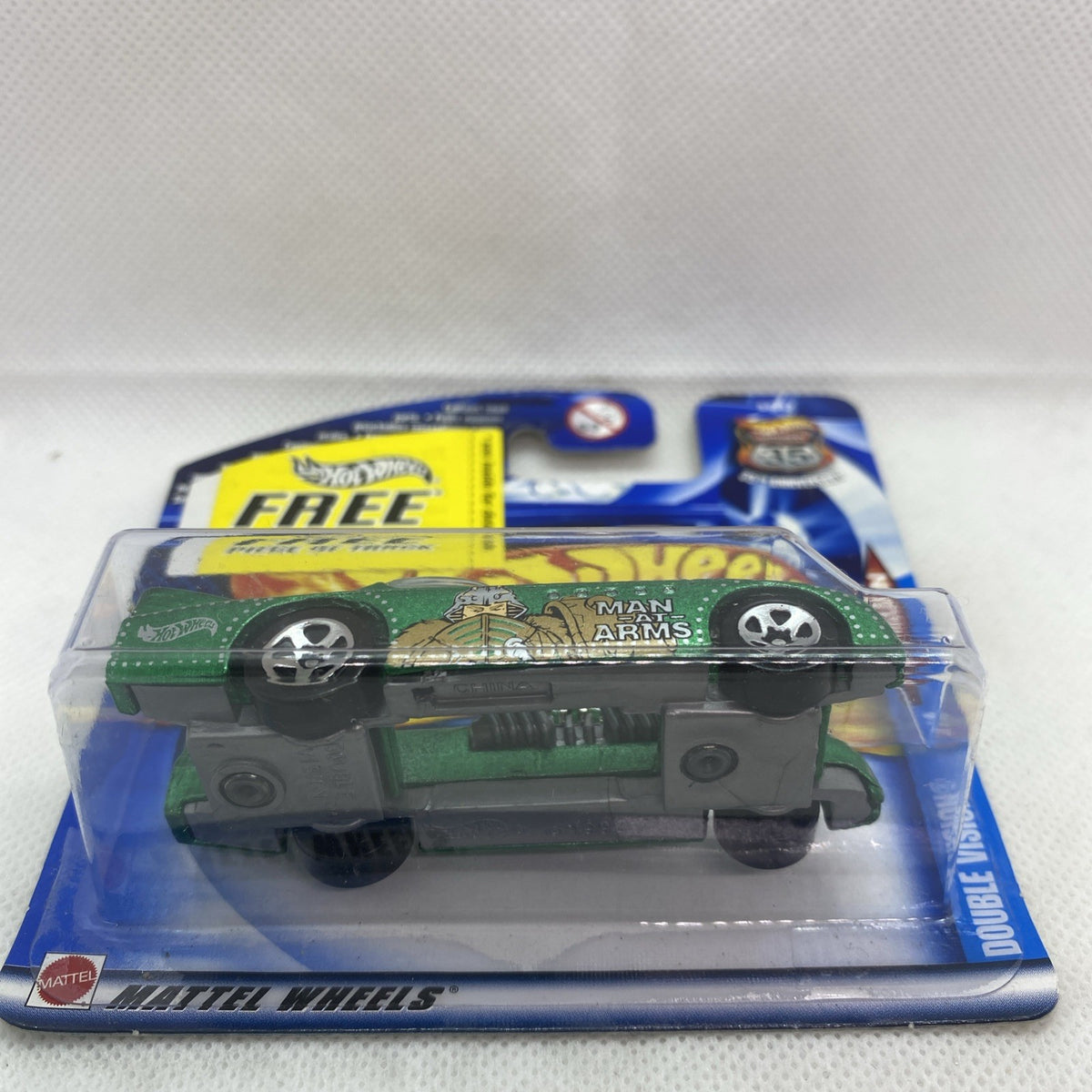 Carded Hot Wheels vehicle in clear blister with green wheels and printed Man Arms graphic