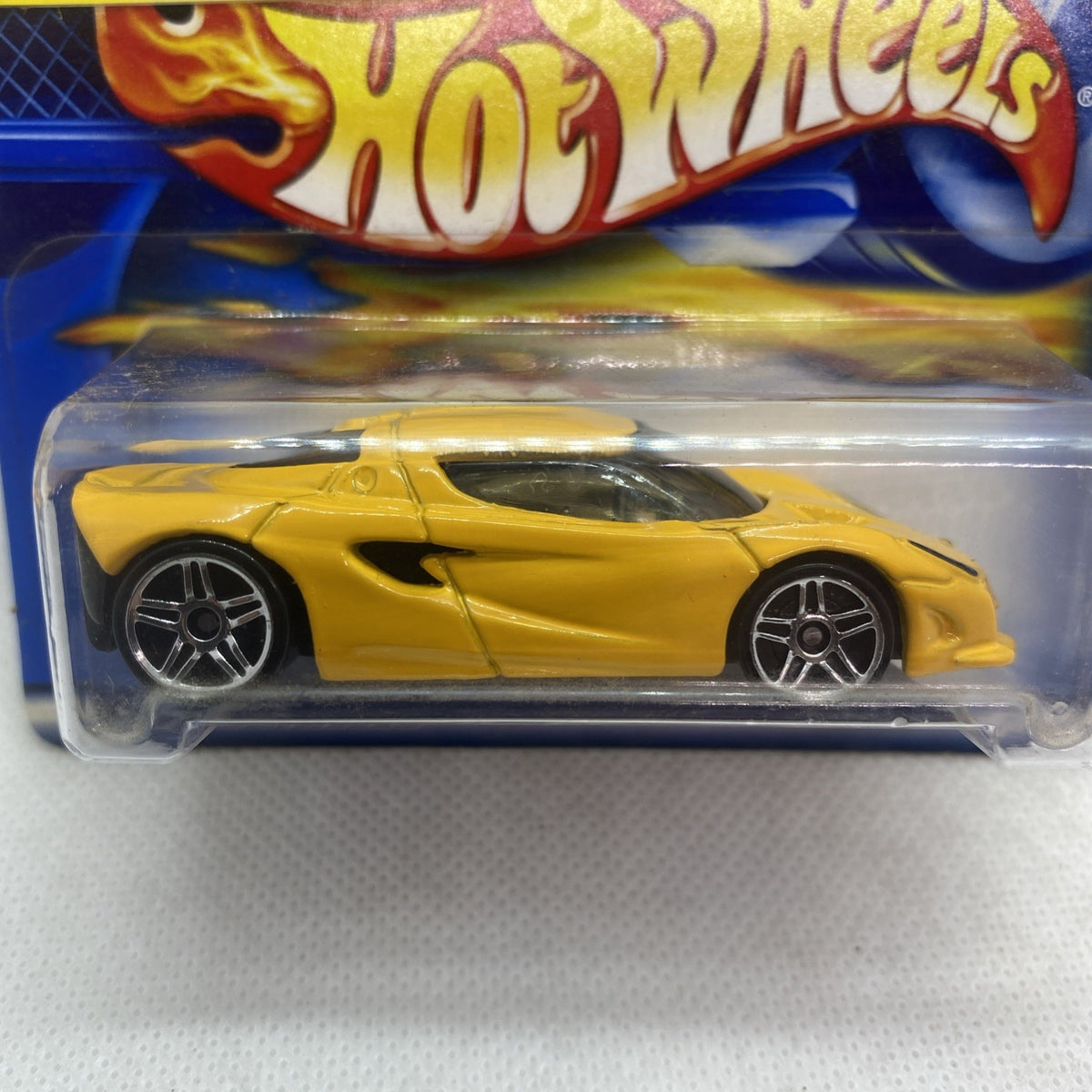 Close-up of yellow die-cast sports car with black window and silver wheels