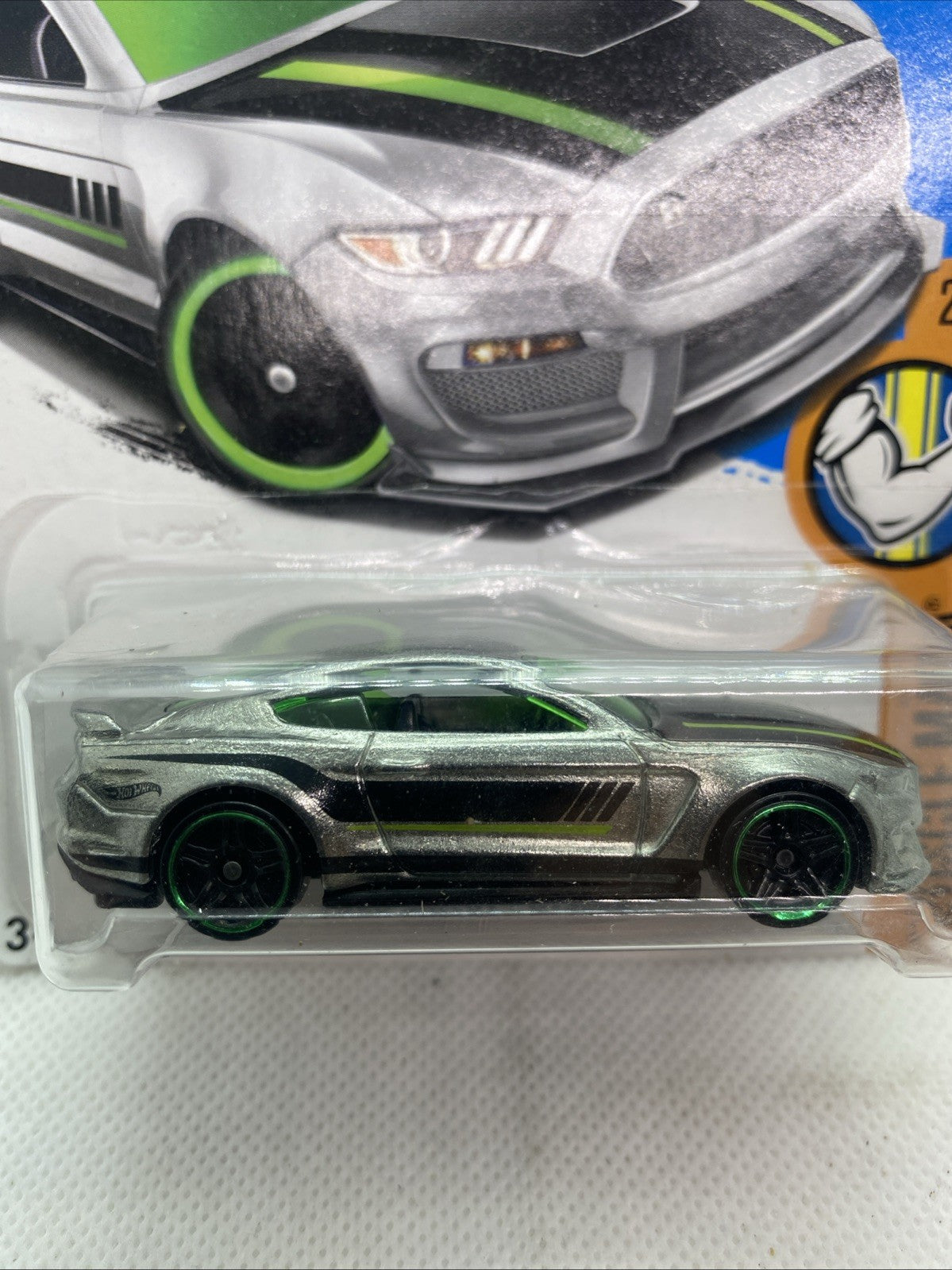 Hot Wheels die-cast muscle car close-up in clear blister, silver with green wheels