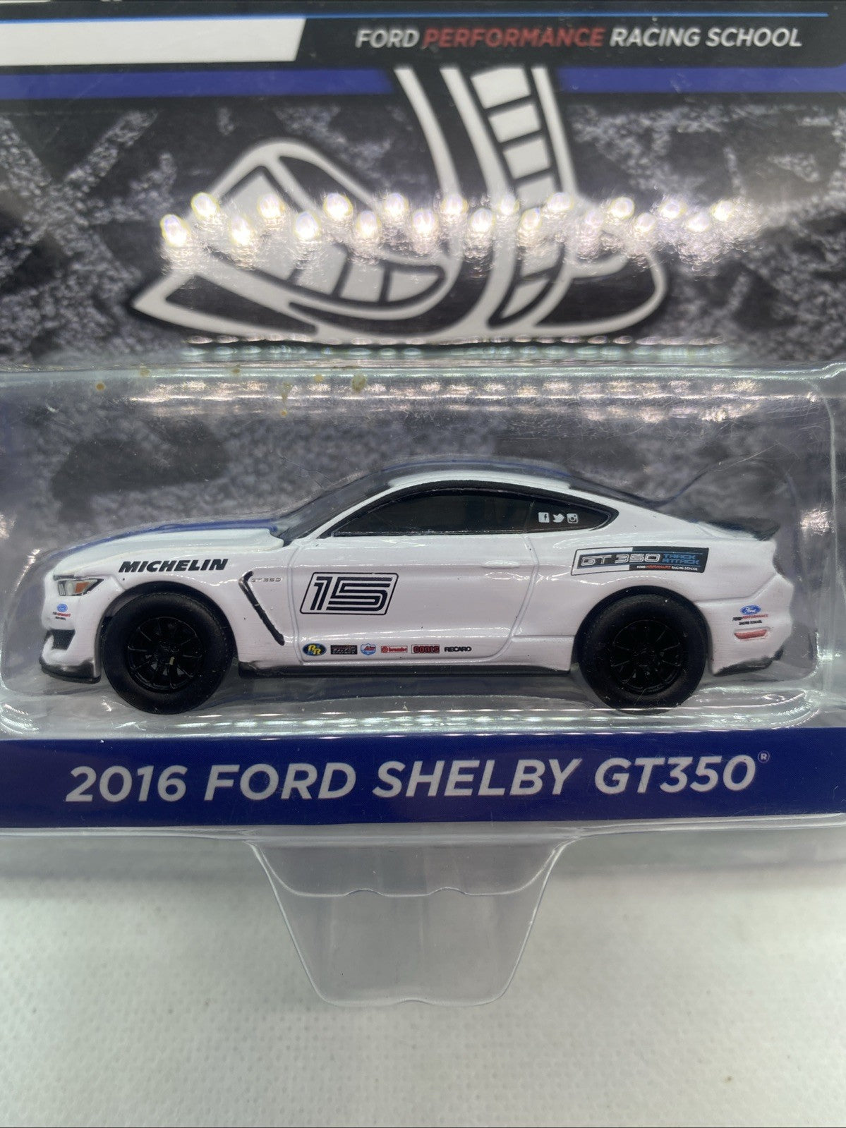 Sealed die-cast race car in blister, side view of white Ford Shelby with black wheels