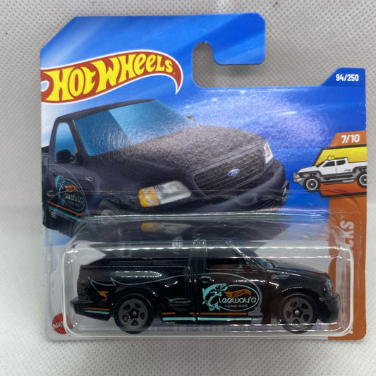 Hot Wheels toy pickup truck in clear blister, black with teal race graphics and chrome wheels.