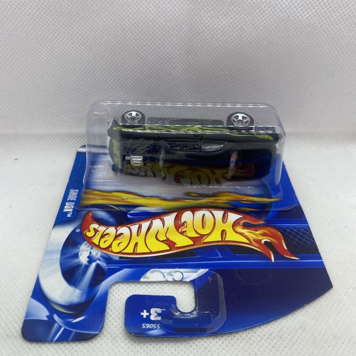 Hot Wheels die-cast car in clear blister, black body with green flame graphics on card