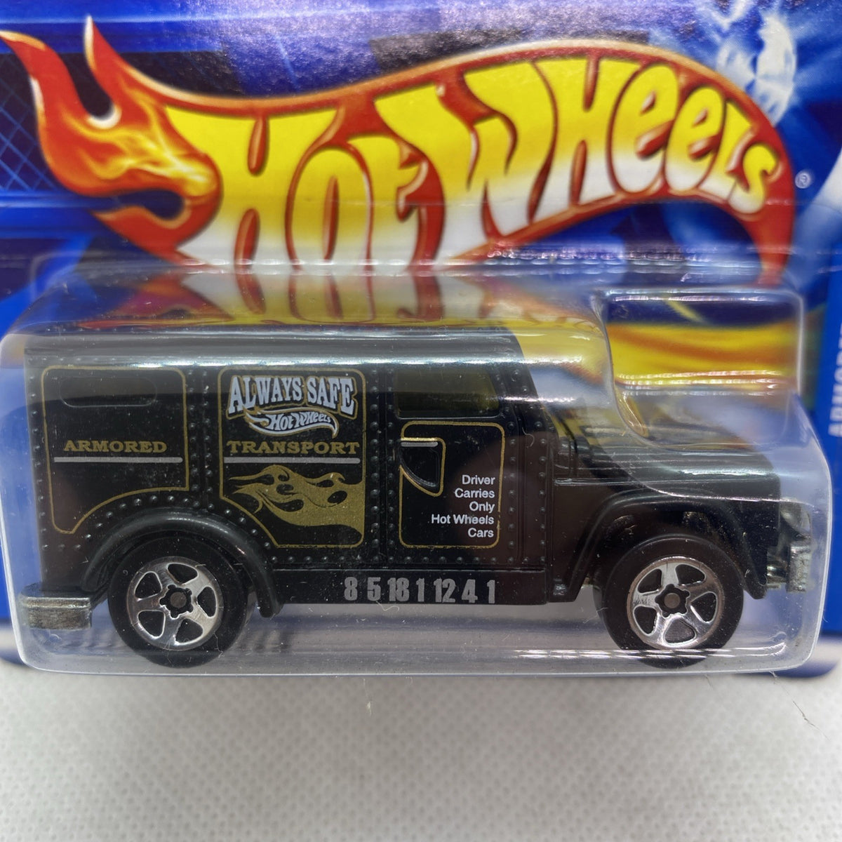 Hot Wheels armored car die-cast close-up in blister, black with gold and yellow flame graphics